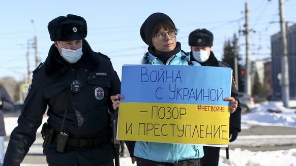 FILE - Police detain a demonstrator with a poster which reads &quot;The war with Ukraine is a shame and a crime&quot; during an action against Russia&#039;s attack on Ukraine in Omsk, Russia, Sunday,  ...