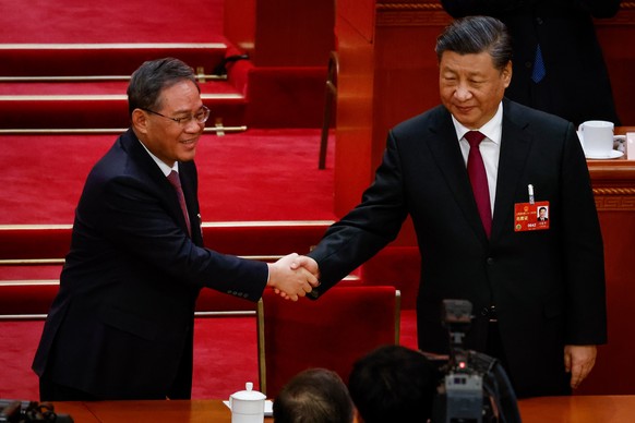 epa10512871 Chinese President Xi Jinping (R) shakes hands with member of the Politburo Standing Committee of the CPC Li Qiang (L) during the Third Plenary Session of the National People&#039;s Congres ...