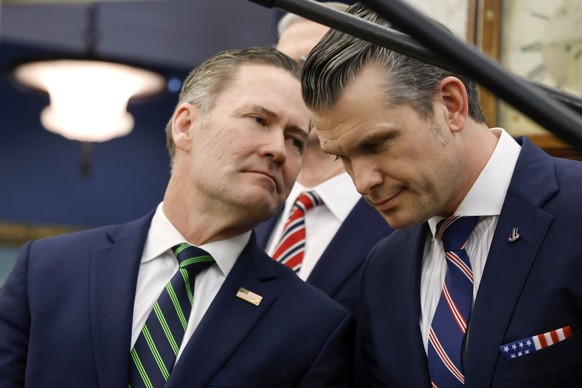 White House national security adviser Mike Waltz, left, speaks with Secretary of Defense Pete Hegseth as President Donald Trump meets with France's President Emmanuel Macron in the Oval Office of ...