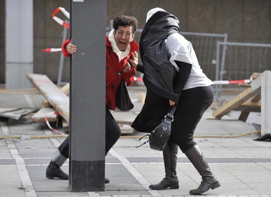 epa02059622 Two women hold on to a metal post in Frankfurt Main, Germany, 28 February 2010. Low &#039;Xynthia&#039; hit Germany with wind speeds of more than 100 km/h. Police and fire brigades are con ...