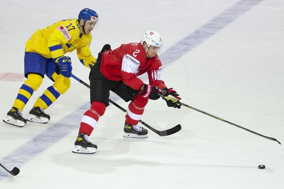 Sweden&#039;s forward Par Lindholm, left, vies for the puck with Switzerland&#039;s defender Santeri Alatalo, right, during the IIHF 2021 World Championship preliminary round game between Switzerland  ...