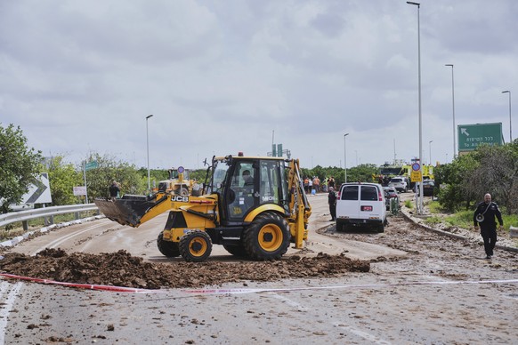 Israeli security forces clean the road from debris where the Israeli military said a projectile fired by Yemen&#039;s Houthi rebels landed in the area of Ben Gurion International Airport near Tel Aviv ...