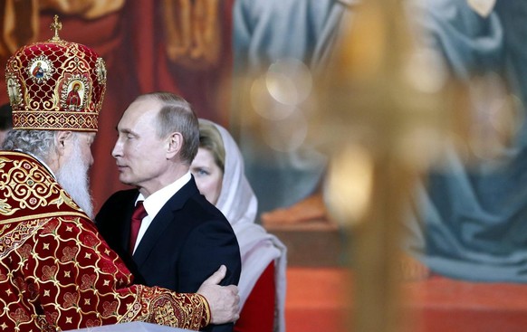 epa04173119 Russian President Vladimir Putin (C) and Patriarch of Moscow and all Russia Kirill (L) speak during the Orthodox Easter service at the Christ the Saviour Cathedral in Moscow, Russia, early ...