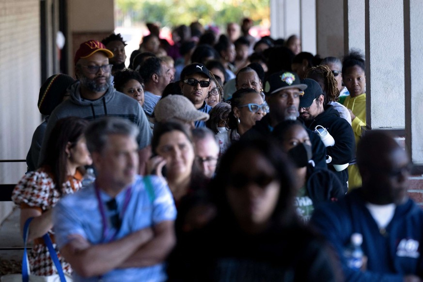 De nombreux fonctionnaires font la queue pour recevoir de la nourriture.