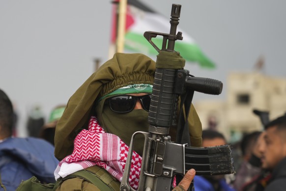 A Hamas fighter takes up a position ahead of handing over four bodies to the Red Cross in Khan Younis, southern Gaza Strip, Thursday, Feb. 20, 2025. Israel has identified three of the bodies as hostag ...