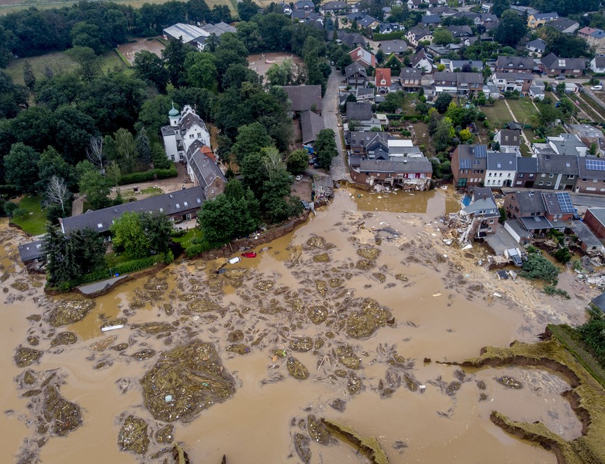 The damaged castle, left, is seen in Erftstadt-Blessem, Germany, Saturday, July 17, 2021. Due to strong rain falls the small Erft river went over the banks causing massive damages. (AP Photo/Michael P ...