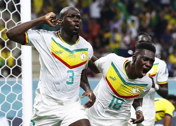 epa10336731 Kalidou Koulibaly (L) of Senegal celebrates with teammate Ismaila Sarr (R) after scoring the 2-1 lead during the FIFA World Cup 2022 group A soccer match between Ecuador and Senegal at Kha ...