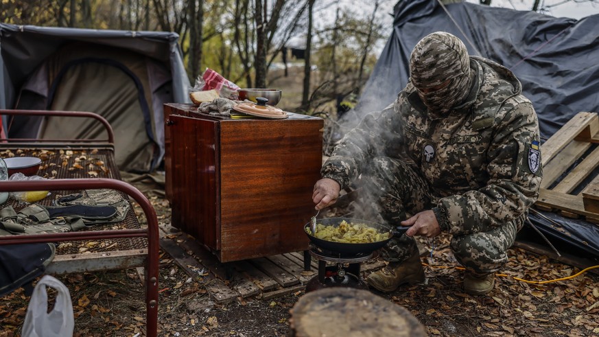 Un soldat ukrainien se prépare à manger, sur la ligne de front dans la région de Kherson, le 6 novembre 2022.