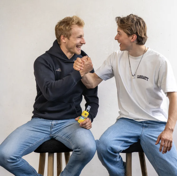 Marco Odermatt (à gauche) tenant un spray de la marque Gaisbock.