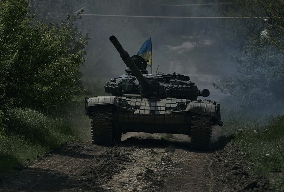 A Ukrainian tank rides near Bakhmut, an eastern city where fierce battles against Russian forces have been taking place, in the Donetsk region, Ukraine, Friday, May 12, 2023. (AP Photo/Libkos)