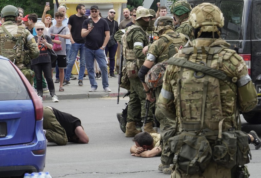 epa10709290 Servicemen from private military company (PMC) Wagner Group detain some civilians as they block a street in downtown Rostov-on-Don, southern Russia, 24 June 2023. Security and armoured veh ...