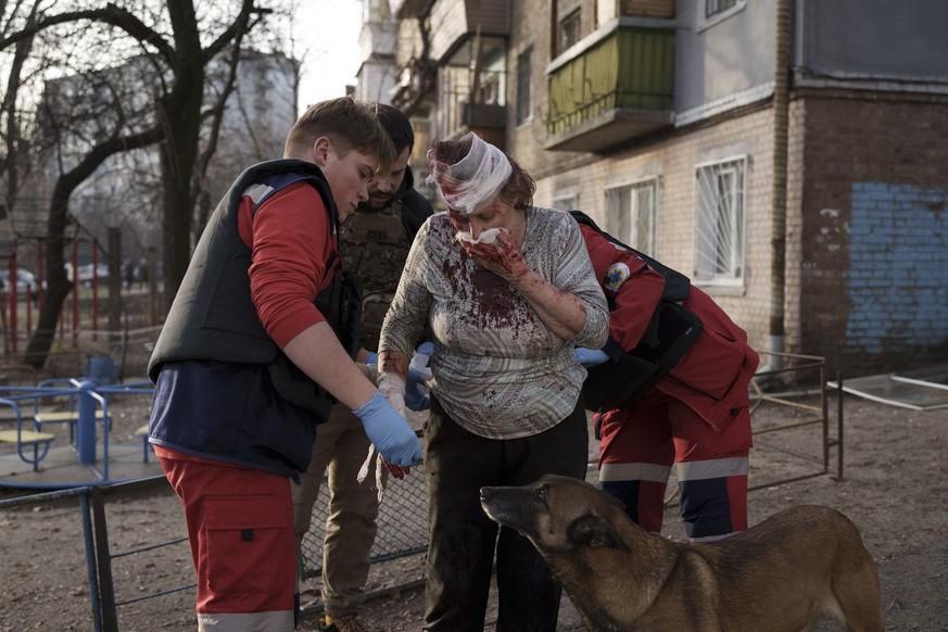 Emergency workers help a woman injured after a Russian attack in Kyiv, Ukraine, Saturday, Dec. 31, 2022. (AP Photo/Roman Hrytsyna)