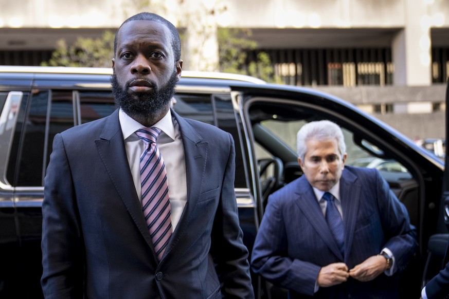 Prakazrel ?Pras? Michel, left, a member of the 1990s hip-hop group the Fugees, accompanied by defense lawyer David Kenner, right, arrives at federal court for his trial in an alleged campaign finance  ...