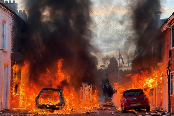 Vehicles set on fire by protesters burn on Lendrick Street in east Belfast, Northern Ireland, on Tuesday, June 9, 2026, after the arrest of a Sudanese man accused of stabbing a man in the northern par ...