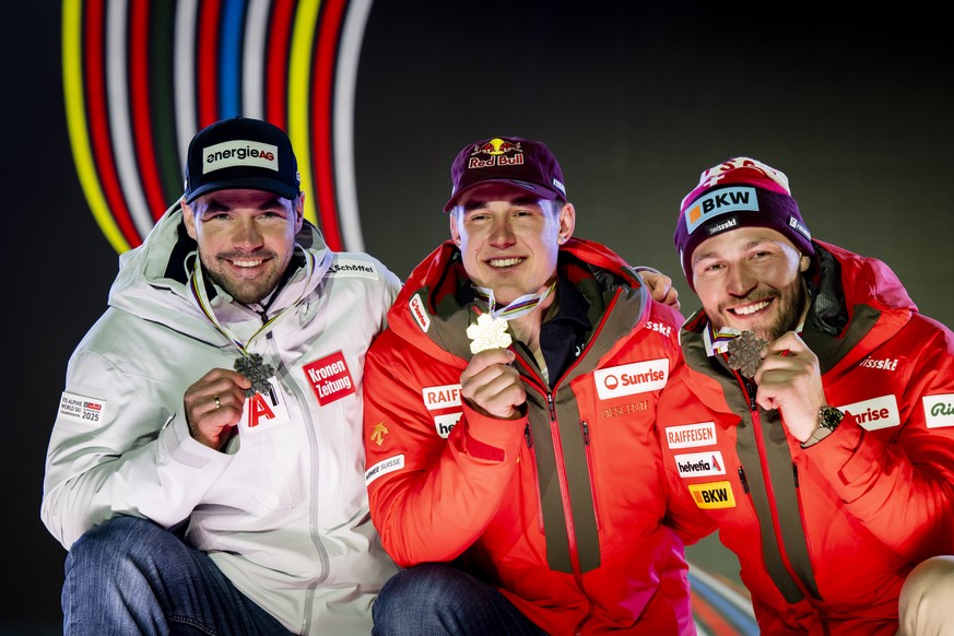 Silver medalist Vincent Kriechmayr of Austria, left, Gold medalist Franjo von Allmen, center, and Bronze medalist Alexis Monney of Switzerland, right, celebrate during the medals ceremony of the men&# ...