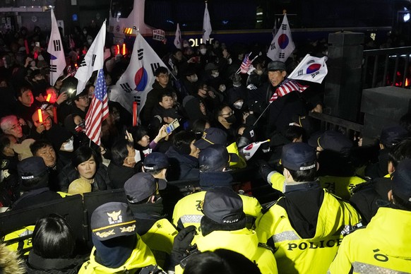 Police officers stand guard as supporters of impeached South Korean President Yoon Suk Yeol try to enter the Seoul Western District Court in Seoul, South Korea, Saturday, Jan. 18, 2025. (AP Photo/Ahn  ...
