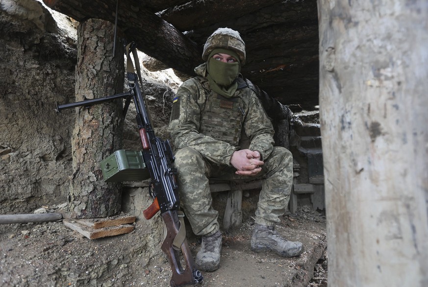 Ukrainian soldiers sits in a fighting position on the line of separation from pro-Russian rebels near Debaltsevo, Donetsk region, Ukraine, Ukraine Friday, Dec 3, 2021. In this Friday, the Ukrainian de ...