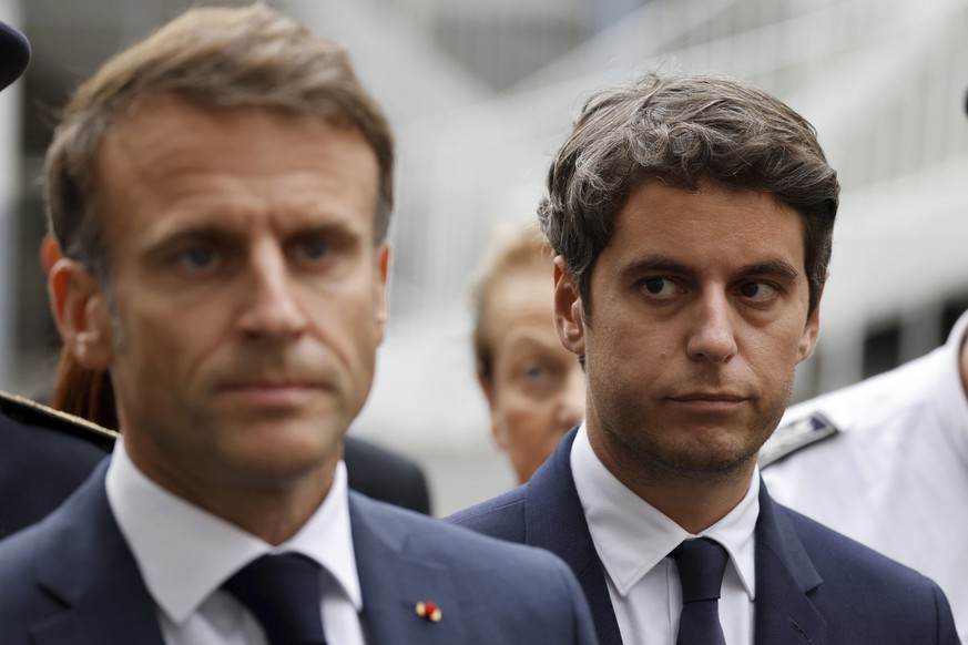 FILE - Then French Education and Youth Minister Gabriel Attal watches French President Emmanuel Macron talking to the press at the Gambetta high school in Arras, northeastern France, Friday Oct. 13, 2 ...