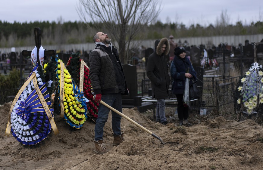 Cemetery worker Artem, looks at the sky exhausted, while working on the grave of Andriy Verbovyi, 55, who was killed by Russian soldiers while serving in Bucha territorial defense, in the outskirts of ...