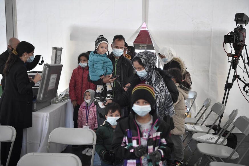 epa09623011 Refugees arrive in a tent in the Moria detention centre for migrants and refugees near Mytilene prior the meeting with Pope Francis on the island of Lesbos, Greece, 05 December 2021. Pope  ...