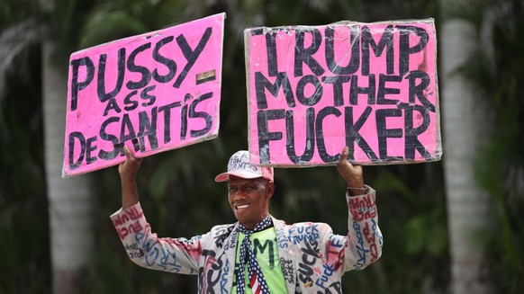 DORAL, FLORIDA - JUNE 12: (EDITORS NOTE: Image contains profanity.) An anti-Trump demonstrator confronts supporters of former President Donald Trump as they wait for him to arrive at the Trump Nationa ...