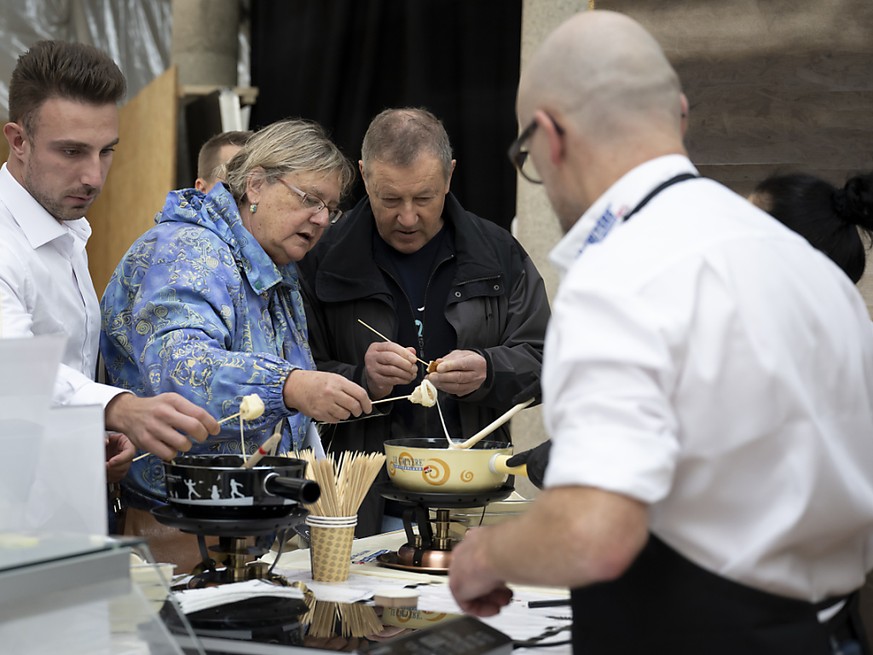 Des visiteurs goûtent des fondues lors du 1er Suisse fondue festival à Fribourg.