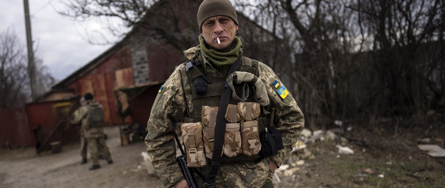 A soldier smokes a cigarette near the frontline in Brovary, on the outskirts of Kyiv, Ukraine, Monday, March 28, 2022. (AP Photo/Rodrigo Abd)