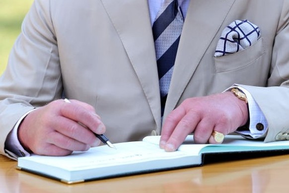 NYAMATA, RWANDA - JUNE 22: Prince Charles, Prince of Wales signs the visitors book during a visit to the Nyamata Church Genocide Memorial where between the 14th and 16th April, 1994 approximately 5,00 ...