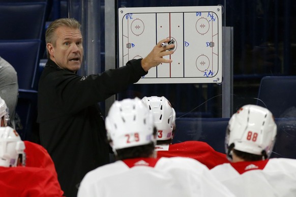 Calgary Flames associate coach Geoff Ward gives instruction during an NHL hockey practice Tuesday, Nov. 26, 2019, in Buffalo, N.Y. Flames general manager Brad Treliving says coach Bill Peters remains  ...