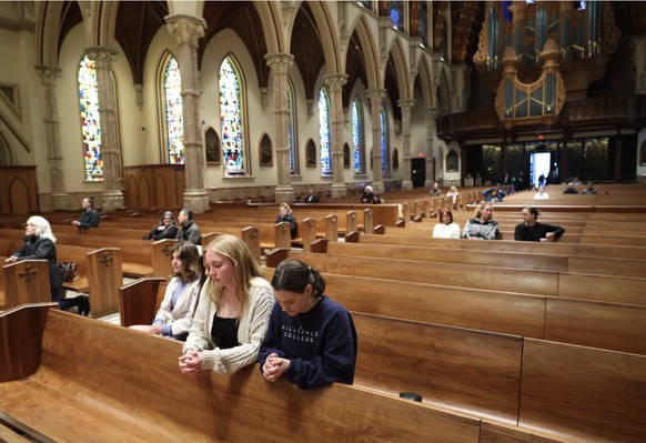 A Chicago, la ville natale du nouveau pape, de jeunes fidèles catholiques prient pour Léon XIV dans la cathédrale du Saint Nom.
