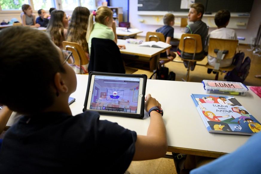 Des eleves de 6eme annee primaire, 6P, enfant de 9-10 ans, suivent a l&#039;aide d&#039;une tablette un cours d&#039;education numerique au sujet des ecrans et des pratiques numeriques ce lundi 12 jui ...