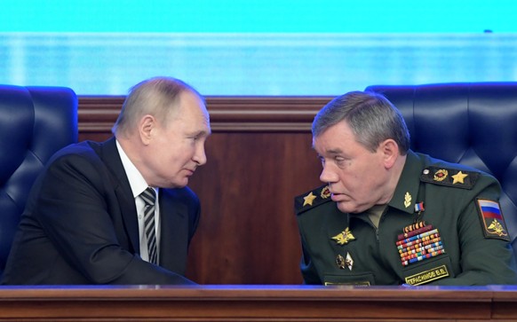epa09652542 Russian President Vladimir Putin (L) listens to Chief of the Russian Armed Forces General Staff, First Deputy Defense Minister, Army General Valery Gerasimov (R) during an expanded meeting ...