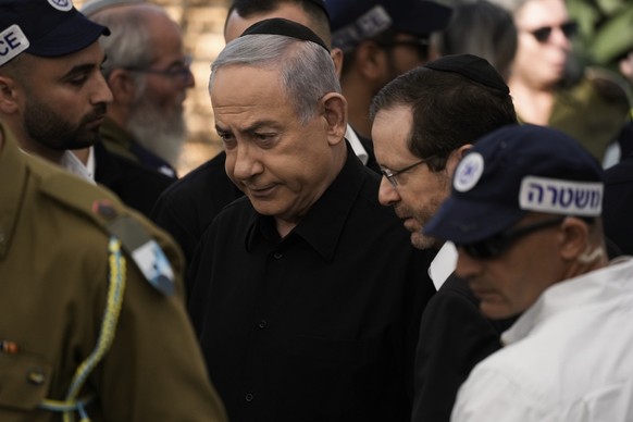 Israeli Prime Minister Benjamin Netanyahu, center, and Israel&#039;s President Isaac Herzog arrive for the funeral of Israeli soldier Master Sgt. Gal Meir Eizenkot, 25, who was killed in fighting in G ...