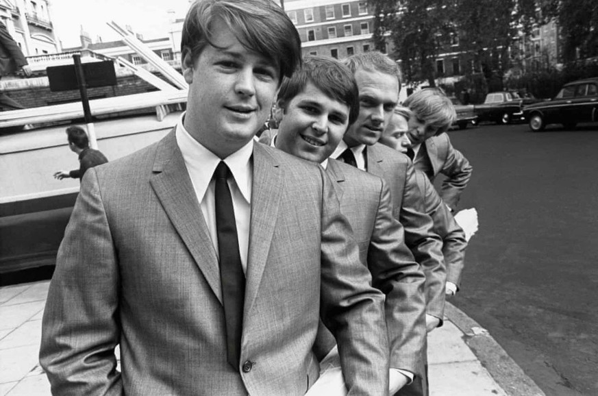 Brian Wilson, Carl Wilson, Mike Love, Al Jardine, Dennis Wilson (peering out at the end) in London, November 1964 by Ken Veeder, Capitol Records
