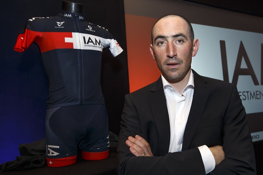 The cyclist of IAM CYCLING team Jerome Pineau, of France, poses near of the new jersey of team for the photographers after the IAM CYCLING team presentation for the 2014 season, in Geneva, Switzerland ...