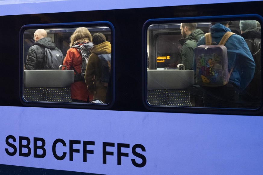 Reisende machen sich zum Aussteigen bereit, fotografiert am Donnerstag, 19. Januar 2023 im Bahnhof Bern. (KEYSTONE/Christian Beutler)