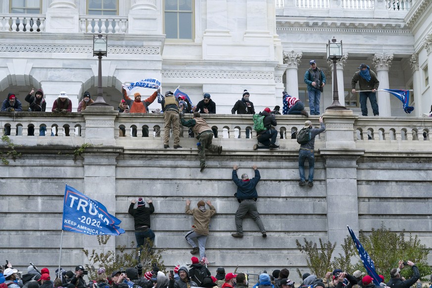 FILE - Violent insurrectionists loyal to President Donald Trump scale the west wall of the the U.S. Capitol in Washington, Jan. 6, 2021. Matthew Greene pleaded guilty on Wednesday, Dec. 22, to stormin ...
