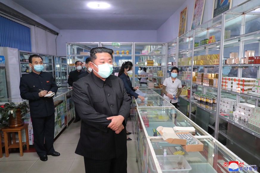 epa09950076 A photo released by the official North Korean Central News Agency (KCNA) shows North Korean leader Kim Jong-un (C) wearing a face mask while inspecting a pharmacy in Pyongyang, North Korea ...