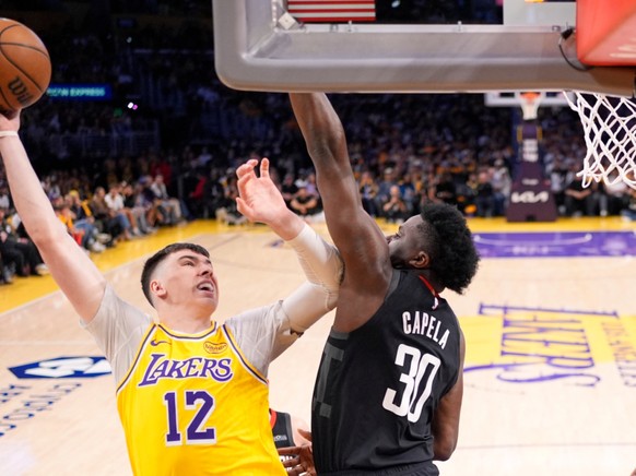 Clint Capela (é droite) tente de s'interposer devant Steven Adams.