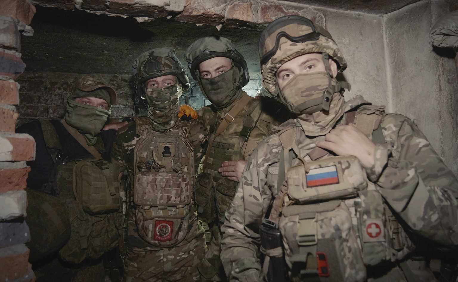 In this photo released by the Russian Defense Ministry Press Service on Tuesday, June 25, 2024, Russian soldiers pose for photo in a shelter at their position in an undisclosed location in Ukraine. (R ...