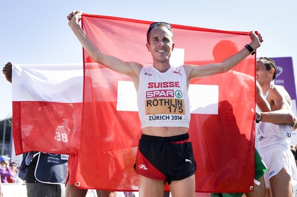 Switzerland&#039;s Viktor Roethlin cheers with the flag after the men&#039;s Marathon in the city centre of Zurich, at the sixth day of the European Athletics Championships in the Letzigrund Stadium i ...