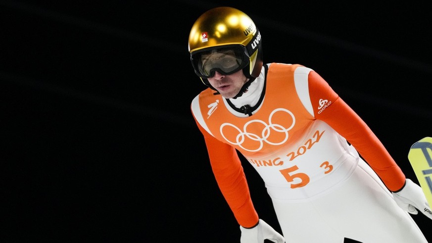 Simon Ammann, of Switzerland, soars through the air during a men&#039;s team ski jumping trial round for competition at the 2022 Winter Olympics, Monday, Feb. 14, 2022, in Zhangjiakou, China. (AP Phot ...