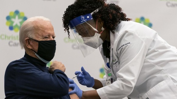 President-elect Joe Biden receives his first dose of the coronavirus vaccine from Nurse partitioner Tabe Mase at Christiana Hospital in Newark Del., Monday, Dec. 21, 2020, from nurse practitioner Tabe ...