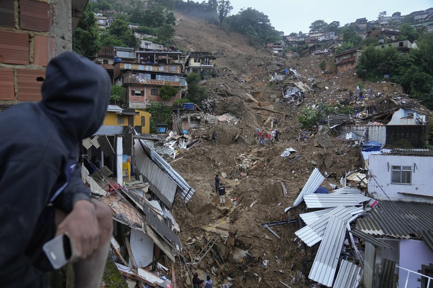 Rescue workers and residents search for victims in an area affected by landslides in Petropolis, Brazil, Wednesday, Feb. 16, 2022. Extremely heavy rains set off mudslides and floods in a mountainous r ...