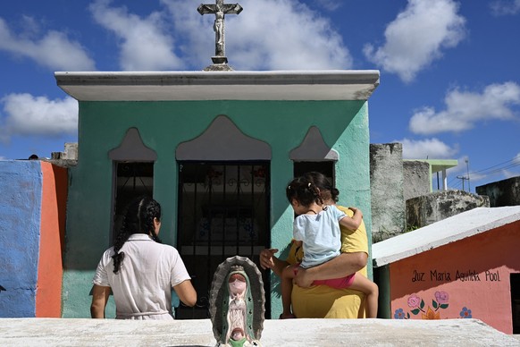 People prepare to clean the remains of a relative ahead of Day of the Dead celebrations at the Pomuch cemetery, Campeche state, Mexico on October 19, 2025. The cleansing ritualówhich combines Mayan an ...