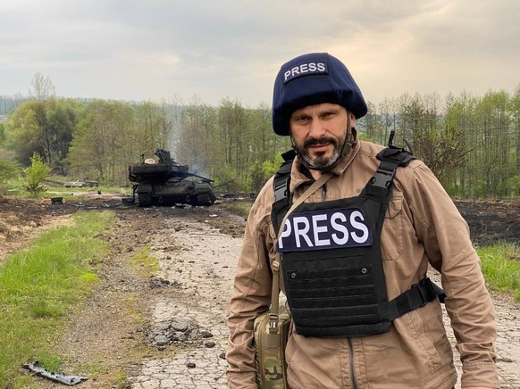 Le journaliste ukrainien Andriy Tsaplienko pose devant la carcasse du T-90M.