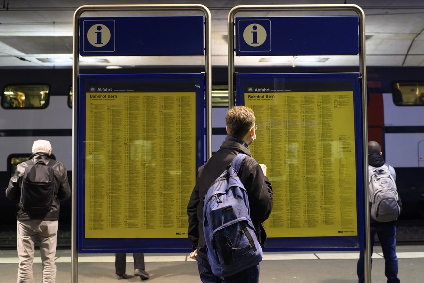 Eine Person schaut sich die Fahrplaene auf den Plakaten an - die Bildschirme, welche die Zuege, Gleise und Abfahrtszeiten anzeigen sollten, sind wegen einer IT-Stoerung bei den SBB ausser Betrieb, am  ...