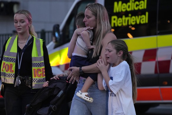 People are led out from Westfield Shopping Centre where multiple people were stabbed in Sydney, Saturday, April 13, 2024. A man stabbed six people to death at the busy Sydney shopping center Saturday  ...