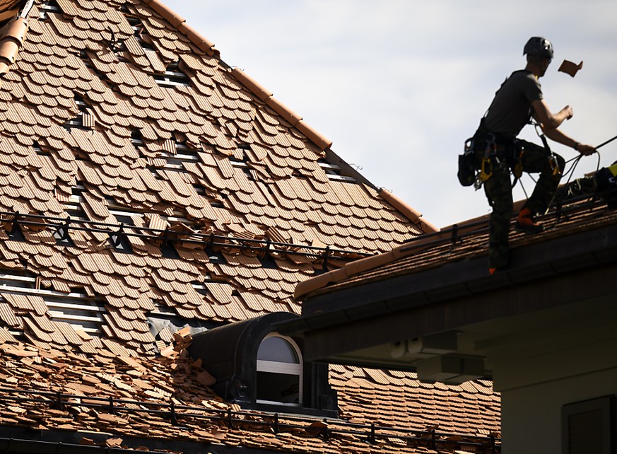 Un militaire de l&#039;Armee Suisse travaille sur un toit endommag