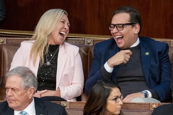epa10391188 Republican Representative elect from Georgia Marjorie Taylor Greene (L) laughs with Republican Representative elect from New York George Santos (R) in the House chamber on the third day of ...